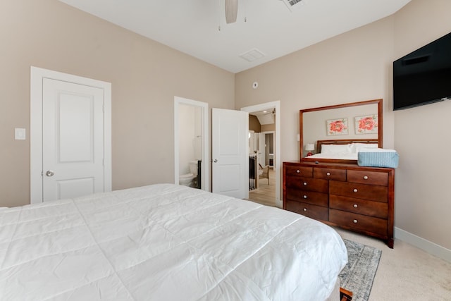 carpeted bedroom with ensuite bath and ceiling fan