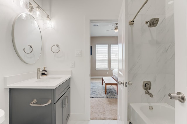 bathroom with vanity, tiled shower / bath combo, and ceiling fan