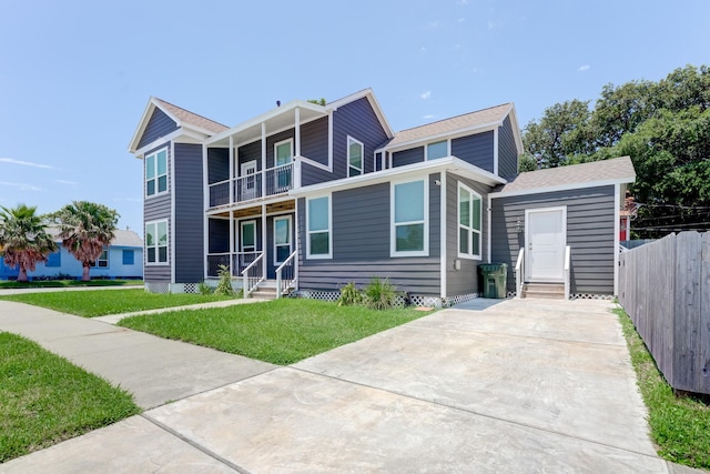 view of front of home with a balcony and a front lawn