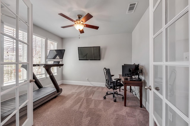 carpeted office space featuring french doors and ceiling fan