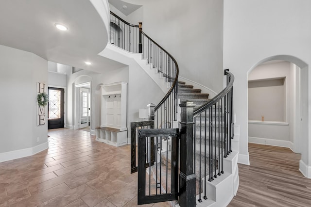 foyer entrance with a towering ceiling and light wood-type flooring