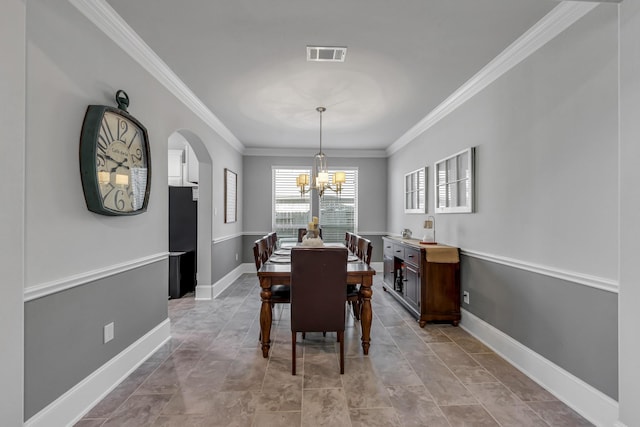 dining room with crown molding and a notable chandelier