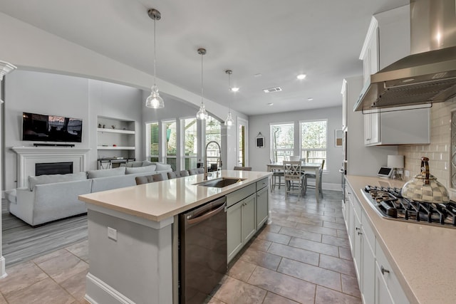 kitchen featuring sink, ventilation hood, dishwasher, pendant lighting, and white cabinets