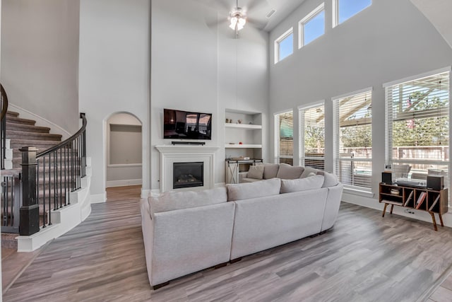 living room with ceiling fan, hardwood / wood-style floors, and built in features