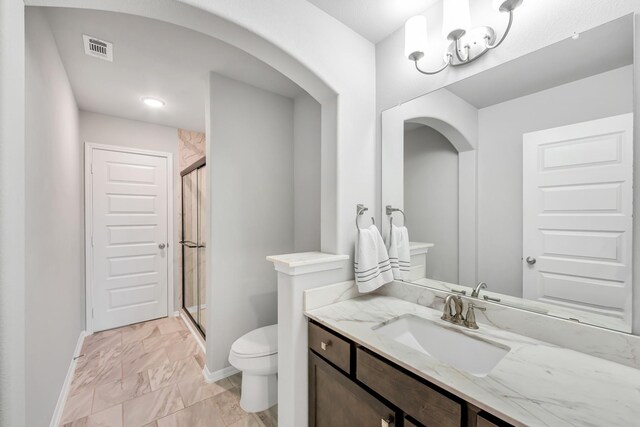 bathroom featuring vanity, toilet, and walk in shower