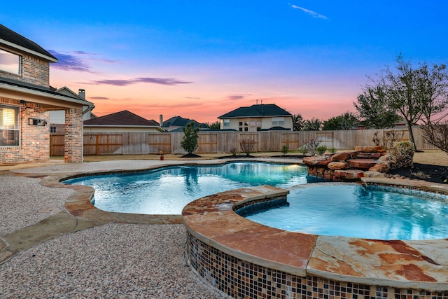 pool at dusk featuring a patio area