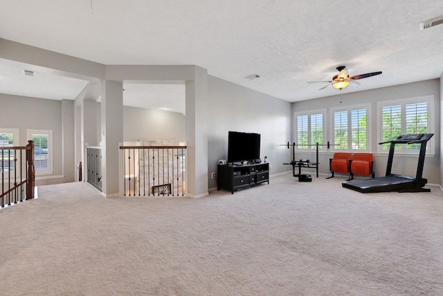 exercise area with ceiling fan, carpet floors, and a textured ceiling