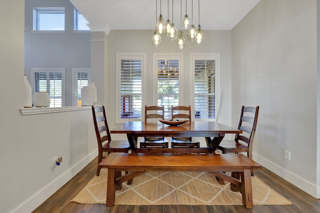 dining area with dark hardwood / wood-style floors and a notable chandelier