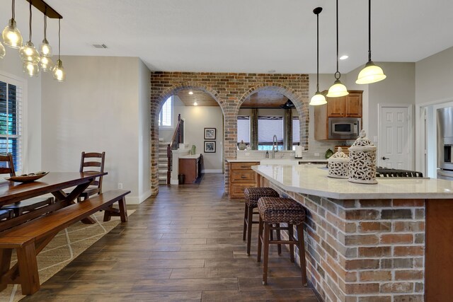 kitchen featuring appliances with stainless steel finishes, dark hardwood / wood-style flooring, decorative light fixtures, and decorative backsplash