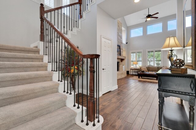 foyer entrance with ceiling fan, dark hardwood / wood-style floors, and a high ceiling