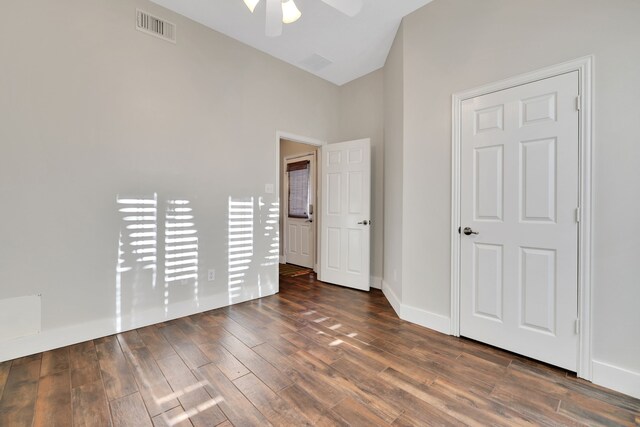 unfurnished bedroom with ceiling fan, dark hardwood / wood-style floors, and vaulted ceiling