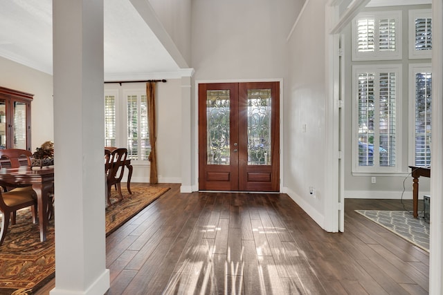 foyer featuring dark hardwood / wood-style flooring, ornamental molding, french doors, and a high ceiling