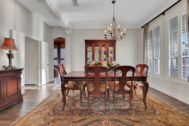 dining room featuring crown molding, dark hardwood / wood-style floors, and an inviting chandelier