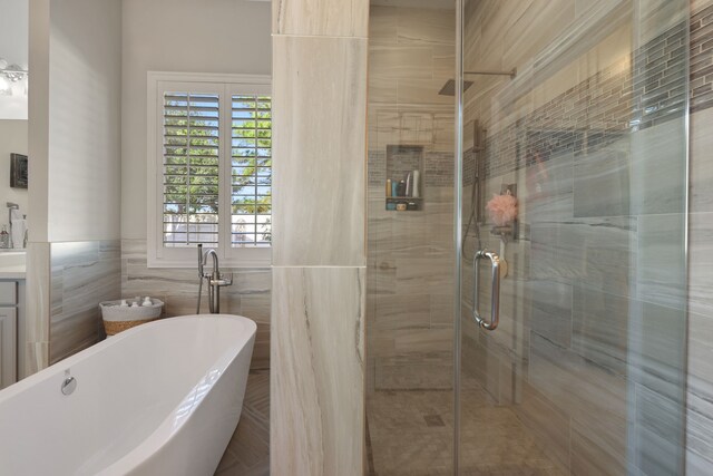 bathroom featuring vanity, separate shower and tub, and tile walls