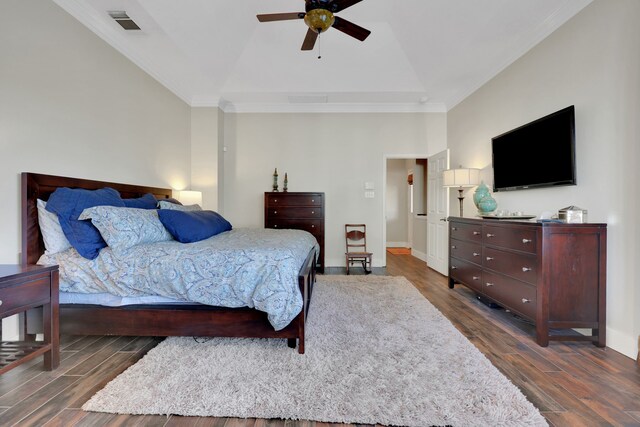 bedroom with ornamental molding, lofted ceiling, dark hardwood / wood-style floors, and ceiling fan