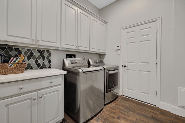 laundry area with separate washer and dryer, dark hardwood / wood-style flooring, and cabinets