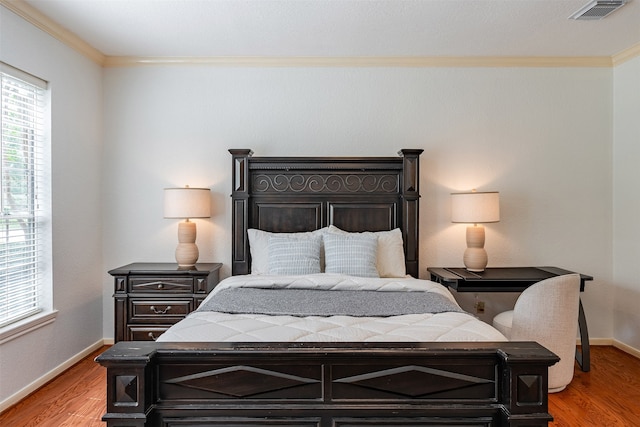 bedroom featuring ornamental molding and light hardwood / wood-style floors