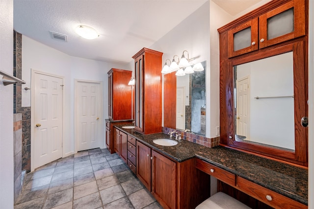 bathroom with vanity, a textured ceiling, and walk in shower