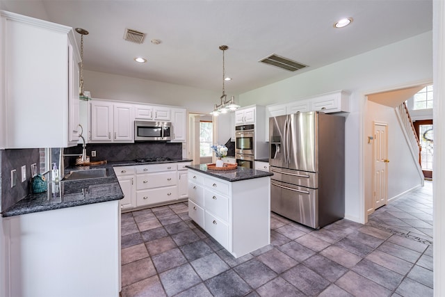 kitchen with sink, white cabinetry, hanging light fixtures, a kitchen island, and stainless steel appliances