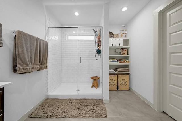 bathroom with tile patterned flooring, vanity, and a shower with door