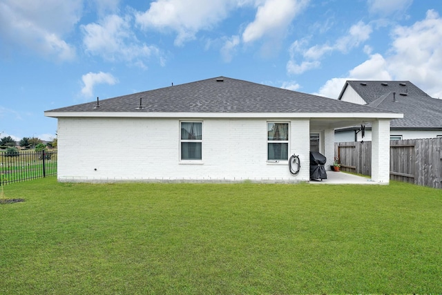 rear view of property featuring a patio and a lawn