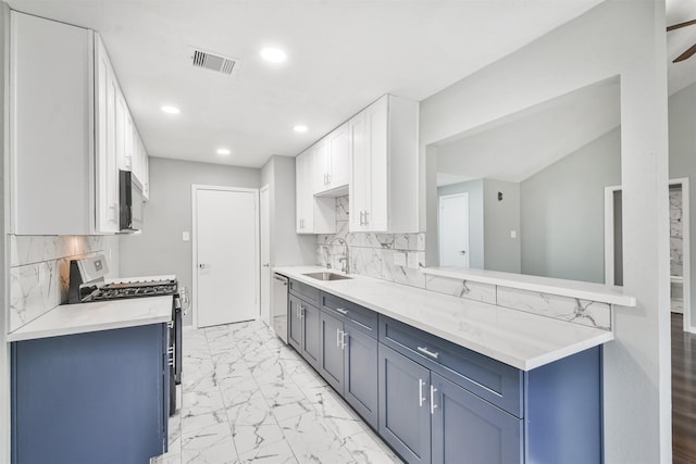 kitchen with sink, white cabinetry, stainless steel appliances, blue cabinets, and decorative backsplash