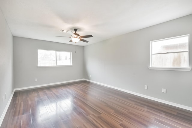 spare room with dark wood-type flooring and ceiling fan