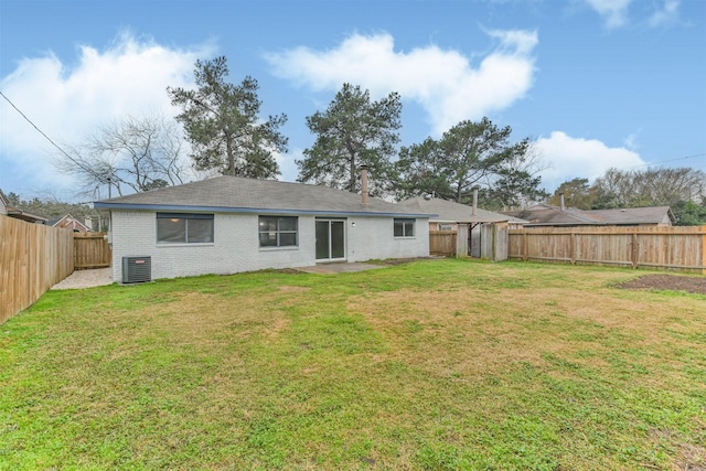 rear view of house featuring cooling unit and a lawn