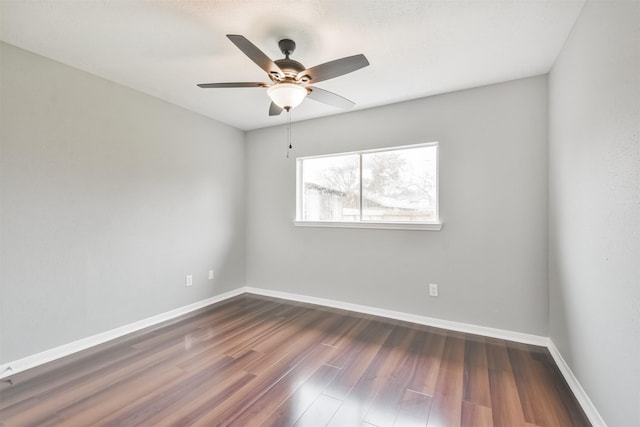 spare room featuring dark hardwood / wood-style flooring and ceiling fan