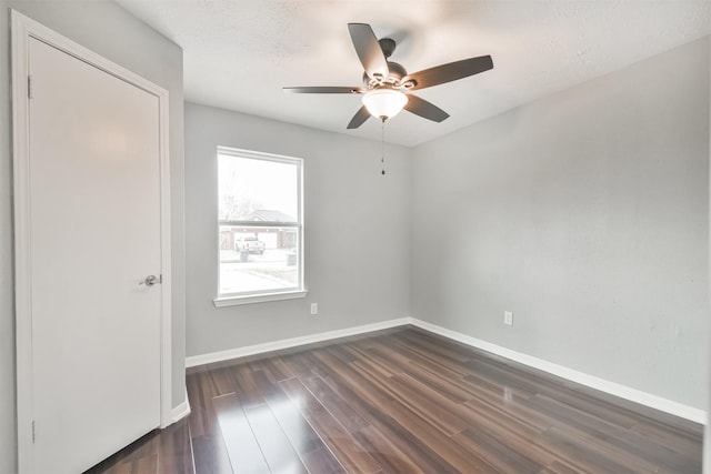 empty room with dark wood-type flooring and ceiling fan