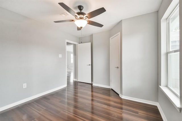 unfurnished bedroom featuring ceiling fan and dark hardwood / wood-style flooring