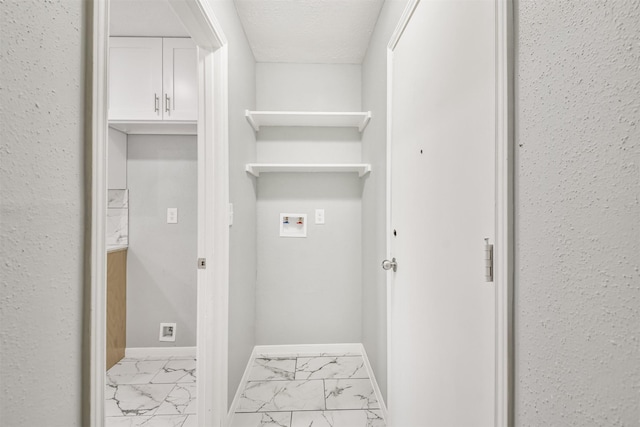 washroom with hookup for a washing machine and a textured ceiling