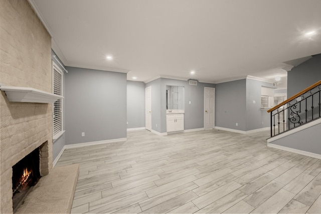 unfurnished living room with ornamental molding, a fireplace, and light hardwood / wood-style flooring