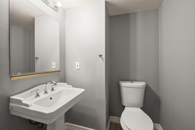 bathroom featuring sink, a textured ceiling, and toilet