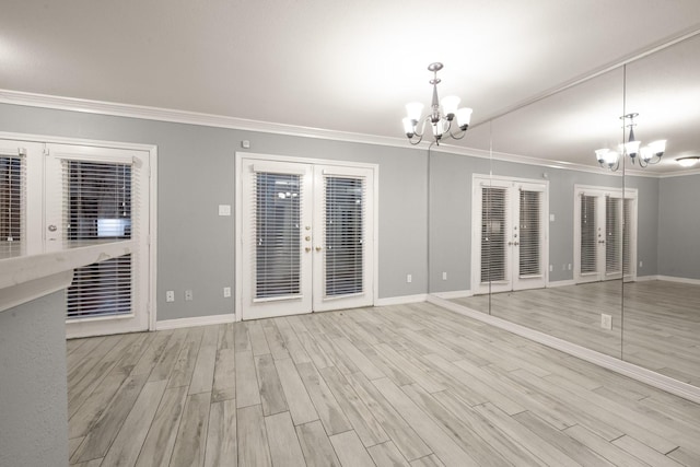 interior space with an inviting chandelier, ornamental molding, french doors, and light wood-type flooring