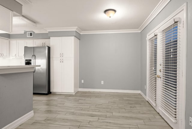 kitchen with white cabinets, crown molding, stainless steel fridge, and light hardwood / wood-style flooring