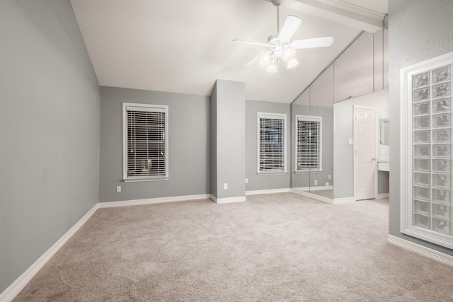 carpeted spare room with lofted ceiling and ceiling fan