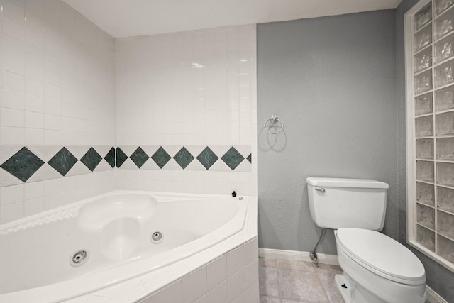 bathroom featuring a relaxing tiled tub, tile patterned floors, and toilet