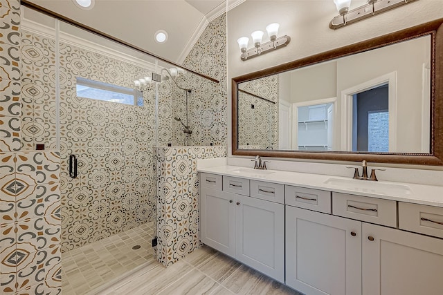 bathroom with a tile shower, vanity, and ornamental molding