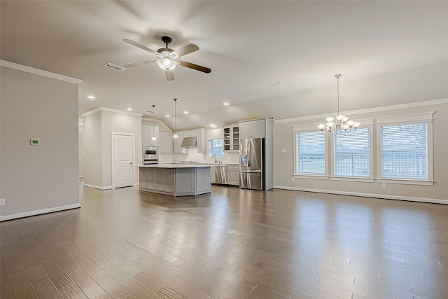 unfurnished living room featuring sink, dark wood-type flooring, ornamental molding, ceiling fan with notable chandelier, and vaulted ceiling