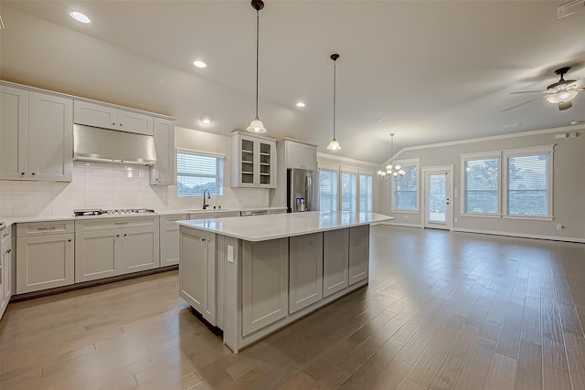 kitchen featuring sink, hanging light fixtures, a center island, stainless steel refrigerator with ice dispenser, and gas stovetop