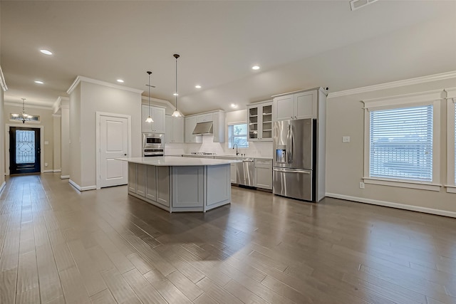 kitchen featuring decorative light fixtures, sink, dark hardwood / wood-style flooring, a center island, and stainless steel appliances