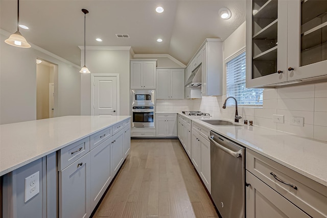 kitchen with sink, tasteful backsplash, decorative light fixtures, appliances with stainless steel finishes, and white cabinets