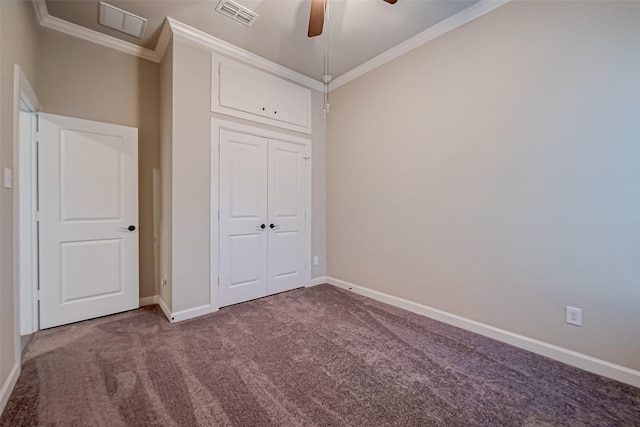 unfurnished bedroom with dark carpet, ornamental molding, a closet, and ceiling fan