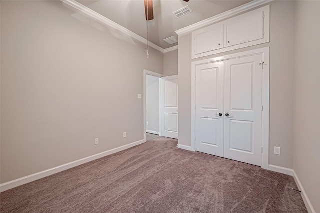 unfurnished bedroom with ceiling fan, a closet, ornamental molding, and carpet