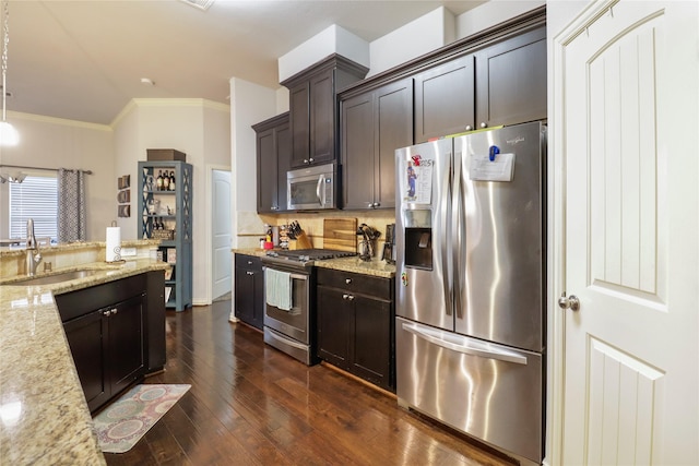 kitchen with sink, stainless steel appliances, dark brown cabinetry, light stone countertops, and decorative light fixtures