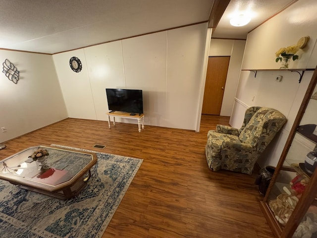 living room featuring dark wood-type flooring and ornamental molding