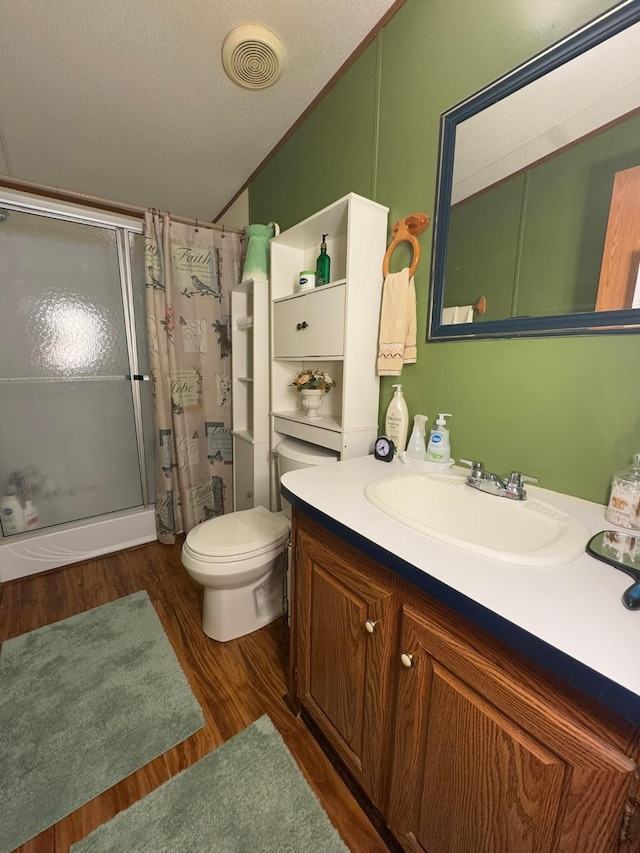 bathroom featuring toilet, vaulted ceiling, vanity, curtained shower, and hardwood / wood-style floors