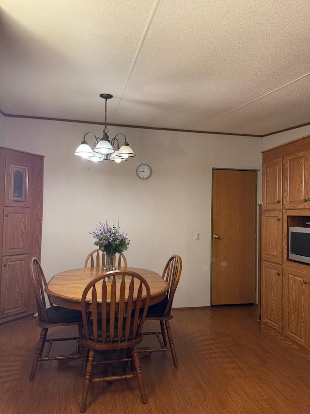 dining space with dark hardwood / wood-style floors, a textured ceiling, and a chandelier