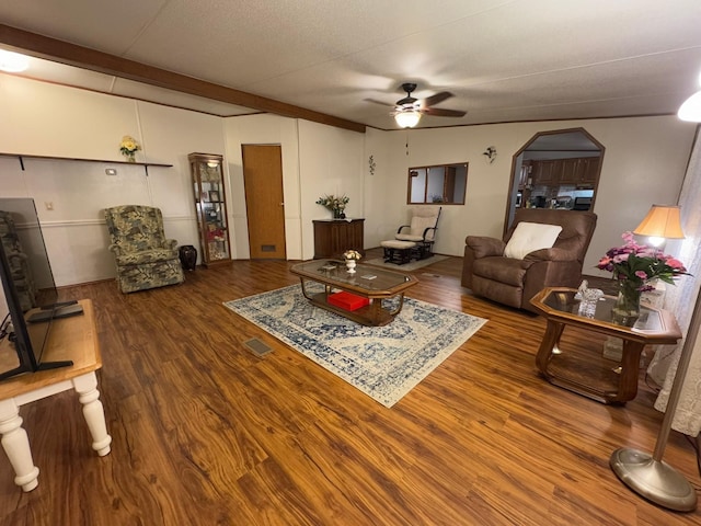 living room with beamed ceiling, hardwood / wood-style floors, and ceiling fan